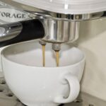 Du café s'écoule dans une tasse blanche sous la buse d'une machine