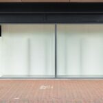 Façade de boutique avec grandes vitrines et porte vitrée sur trottoir