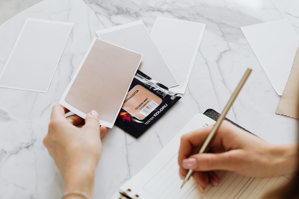 Mains écrivant dans un carnet, cartes et emballage de poudre sur une table en marbre