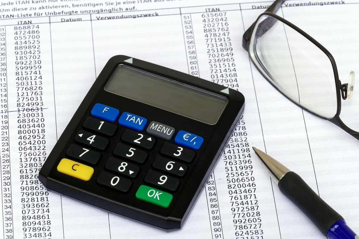 Une calculatrice, des lunettes, un stylo et des documents comptables